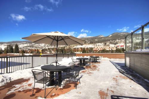 a patio with tables and chairs and an umbrella at Slopeside in Keystone
