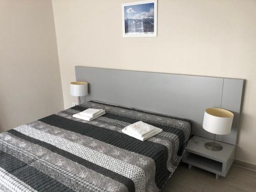 a bedroom with a bed with two lamps on it at Apartament studio Czarna Góra II in Sienna
