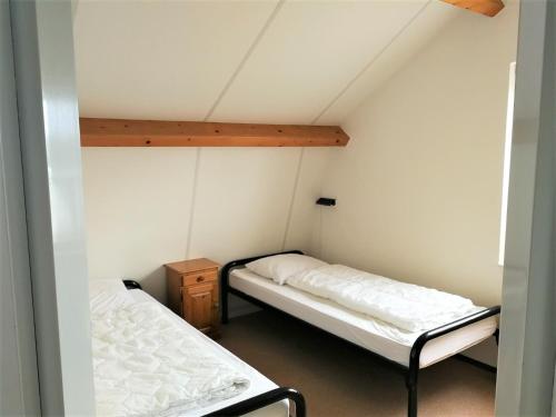 a small room with two beds in a attic at Vakantiehuis Domburg 100 meter van het strand - veel privacy - eigen parkeerplaats. in Domburg