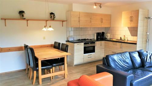 a kitchen and living room with a table and a couch at Vakantiehuis Domburg 100 meter van het strand - veel privacy - eigen parkeerplaats. in Domburg