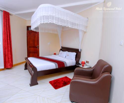 una camera con un letto e un divano di Mbale Rosewood Hotel a Mbale