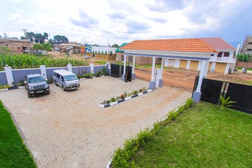 two cars parked in a parking lot in front of a house at Mbale Rosewood Hotel in Mbale