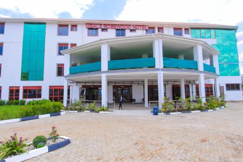 a large white building with a courtyard in front of it at Mbale Rosewood Hotel in Mbale