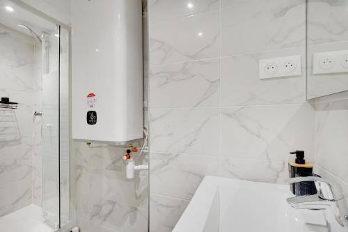 a white bathroom with a shower and a sink at CMG - Cosy studio Le Marais in Paris