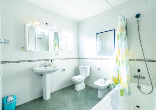 a white bathroom with a toilet and a sink at Aldea Beach 39 - Fantástica casa a pie de playa in Manilva