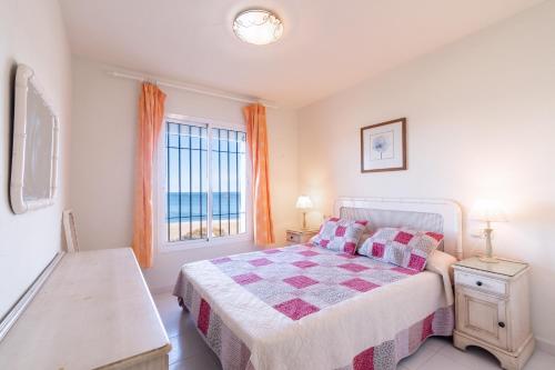 a bedroom with a bed with a view of the ocean at Aldea Beach 39 - Fantástica casa a pie de playa in Manilva