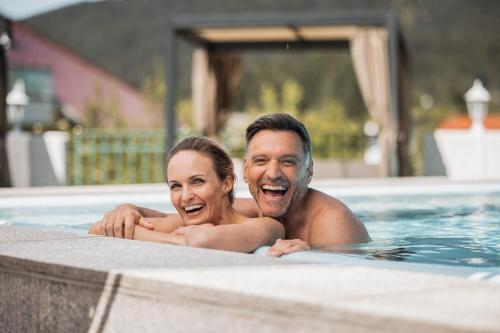 a man and a woman in a swimming pool at Wellnesshotel Schönruh - Adults only in Seefeld in Tirol