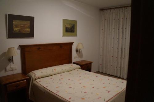 a small bedroom with a bed and a window at Apartamentos Proamar in Torre del Mar