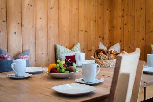 a table with a bowl of fruit and a basket of bread at Landhaus Geierstanger in Wallgau