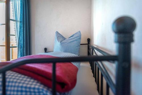 a bed with blue and white pillows on it at Landhaus Geierstanger in Wallgau