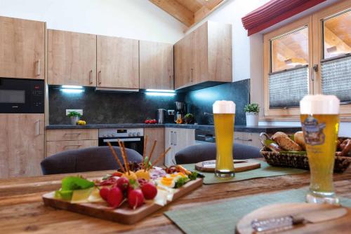 a kitchen with a table with food and two glasses of beer at Landhaus Geierstanger in Wallgau