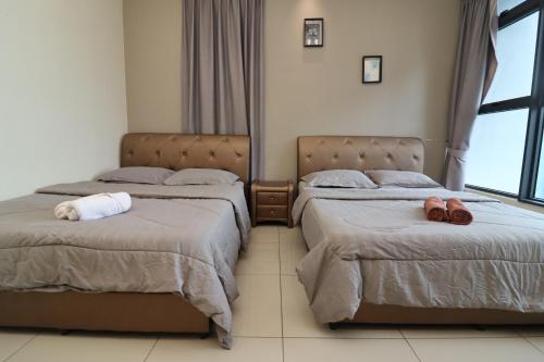 een slaapkamer met 2 bedden en handdoeken bij Mykey Atlantis A-32-05 Melaka City in Melaka