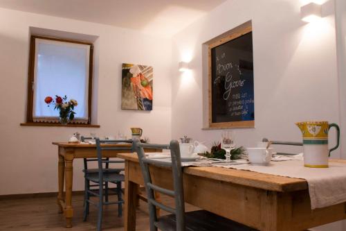 a dining room with a table and a chalkboard on the wall at Storie di bosco in Villa Lagarina