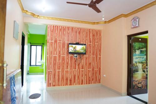 a room with a wooden wall with a tv on it at Dhanashree Riverview Hotel in Corgao