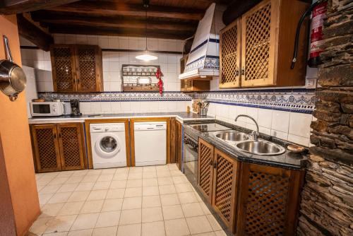 een keuken met een wastafel en een wasmachine bij Sierra de Gata EL MIRADOR DE ROBLEDILLO in Robledillo de Gata