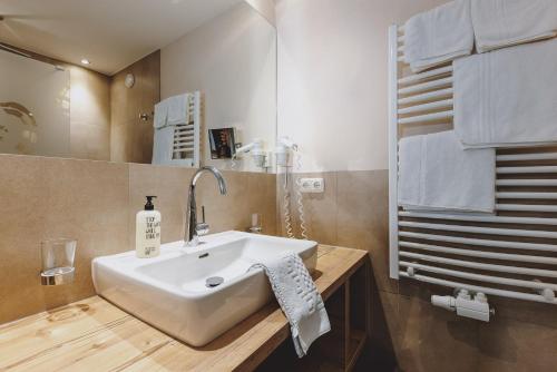 a bathroom with a white sink and a mirror at Der Gollinger in Saalbach Hinterglemm