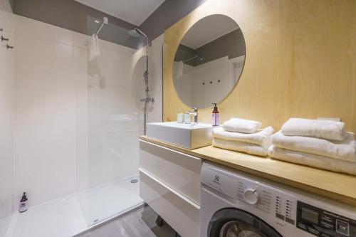 y baño con lavadora y espejo. en Apartament BIRCH TREE SurfingBird Dźwirzyno en Dźwirzyno