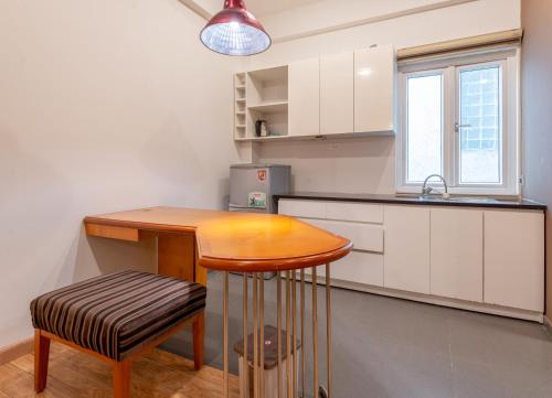 a kitchen with a wooden table and a stool at Hanoi Golden Sunshine Villa Hotel and Travel in Hanoi