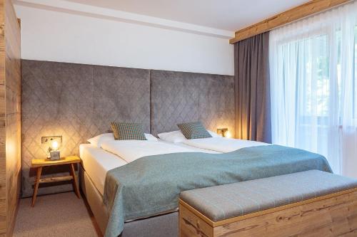 a hotel room with two beds and a window at Der Gollinger in Saalbach Hinterglemm