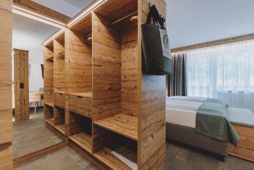 a room with a bed and a wooden wall at Der Gollinger in Saalbach Hinterglemm