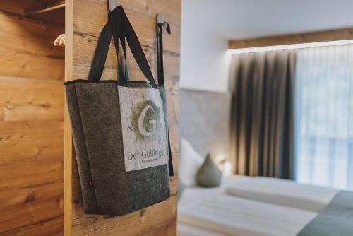 a bag hanging on a wall next to a bed at Der Gollinger in Saalbach Hinterglemm