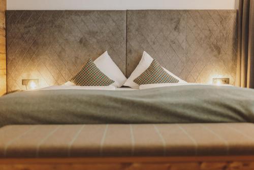 a bedroom with a bed with pillows on it at Der Gollinger in Saalbach Hinterglemm