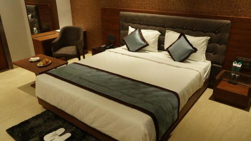 舍爾第的住宿－Alaukik Hotel，酒店客房带一张大床和一把椅子