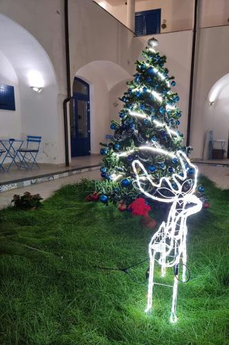 a christmas tree with a reindeer in front of it at Sognando Vietri e SPA Esclusiva P T in Aversa