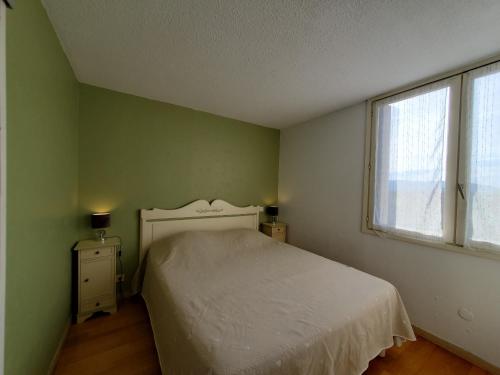 um quarto com uma cama branca e uma janela em Miougrano 3 Pieces Climatise 48m2 5 Personnes Park em Fréjus