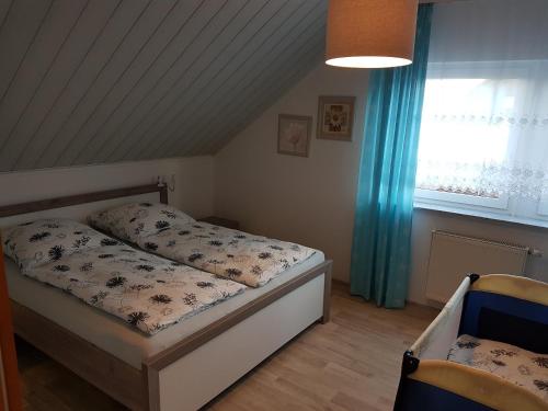 um pequeno quarto com uma cama e uma janela em FERIENHAUS FISCHER em Zweibrücken