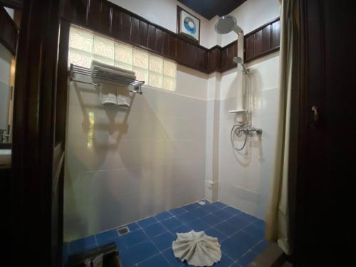 Vangsavath Hotel في لوانغ برابانغ: حمام مع أرضية من البلاط الأزرق ودش