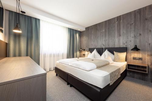奧伯古格爾的住宿－維爾沃公寓式酒店，一间卧室设有一张大床和木墙
