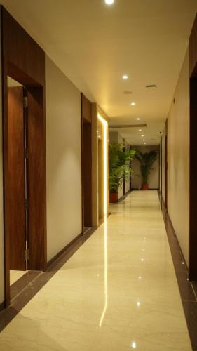 a hallway of an office building with potted plants at Alaukik Hotel in Shirdi