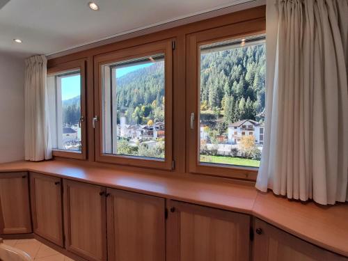 a room with three windows with a view at NUOVISSIMO BILOCALE PALAZZINA VENERI in Cogolo