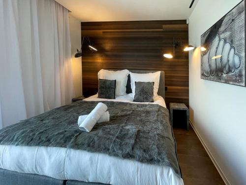 une chambre avec un grand lit avec un mur en bois dans l'établissement Villa Sagittaire, à Saint-Tropez