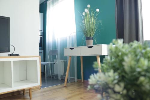 una sala de estar con una mesa con una maceta. en Apartament Swarzędz, en Swarzędz