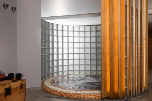 a bath tub in a room with a tiled wall at Hotel Du Lac Congress Center & Spa in Ioannina