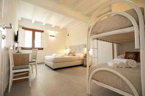 a bedroom with two bunk beds and a desk at La Corte del Sole in Calatafimi