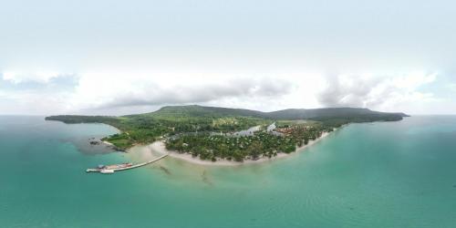 an island in the ocean with a boat in the water at Mafiya Resort in Koh Rong Island