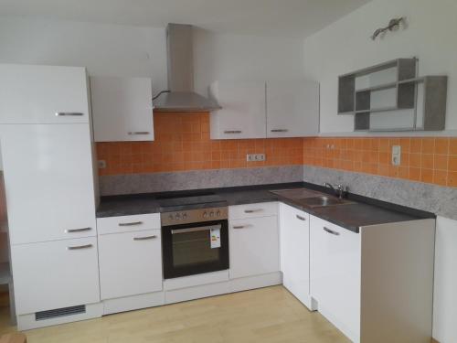 a kitchen with white cabinets and a stove top oven at Appartment für 4 bis 8 Personen in Bad Zell