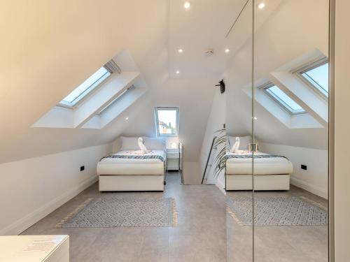 a attic bedroom with two beds and skylights at The Otter - Uk40927 in Holdenhurst