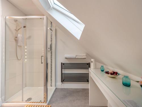 een witte badkamer met een douche en een wastafel bij The Otter - Uk40927 in Holdenhurst