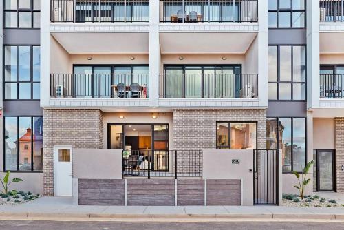 an apartment building with balconies on a street at Jewel on Jubilee - New 1 Bed Apt with Parking in Port Adelaide