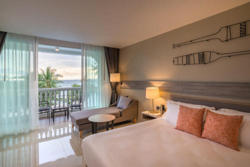 a hotel room with a bed and a balcony at Centara Ao Nang Beach Resort & Spa Krabi - SHA Plus in Ao Nang Beach