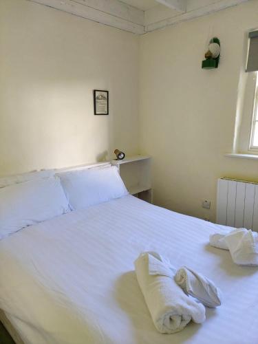 a bedroom with a white bed with towels on it at Corofin Lake Cottages in Corrofin