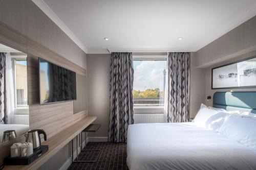 Habitación de hotel con 2 camas y ventana en City Sleeper at Royal National Hotel, en Londres