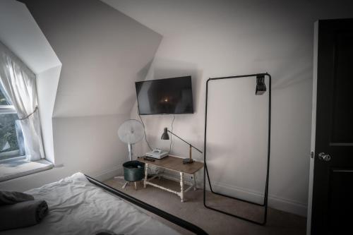 a bedroom with a bed and a desk with a mirror at Victorian Penthouse with panoramic sea views in Ilfracombe
