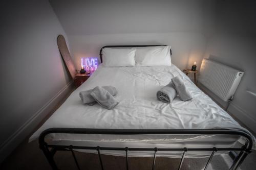a bed with two pillows on it in a room at Victorian Penthouse with panoramic sea views in Ilfracombe
