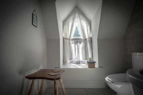 a bathroom with a toilet and a window at Victorian Penthouse with panoramic sea views in Ilfracombe