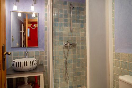 bagno con doccia, lavandino e specchio di Garxo Apartamentos a Isaba